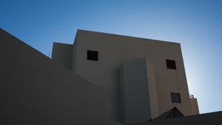 Image of building on campus with the sun behind it